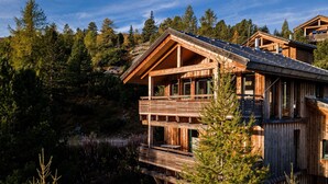 A wooden cabin with a balcony, surrounded by dense forest. - Chalet in Austria Near Ski Slope & Sauna (Stadl-Predlitz)