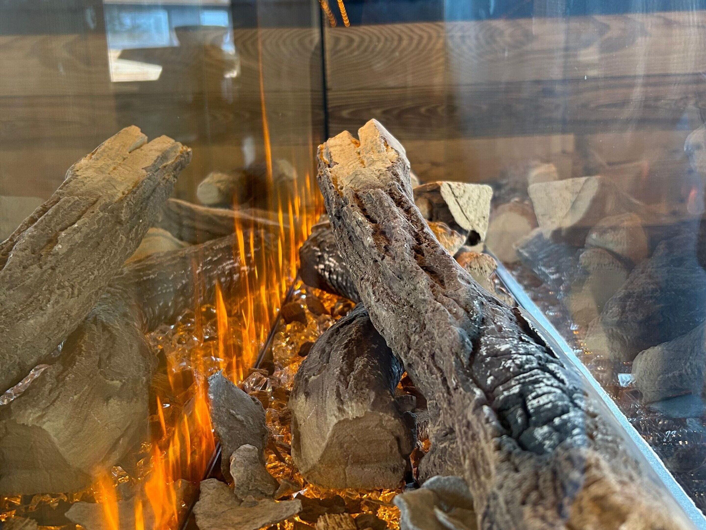 A close-up of a fire burning with logs and rocks.