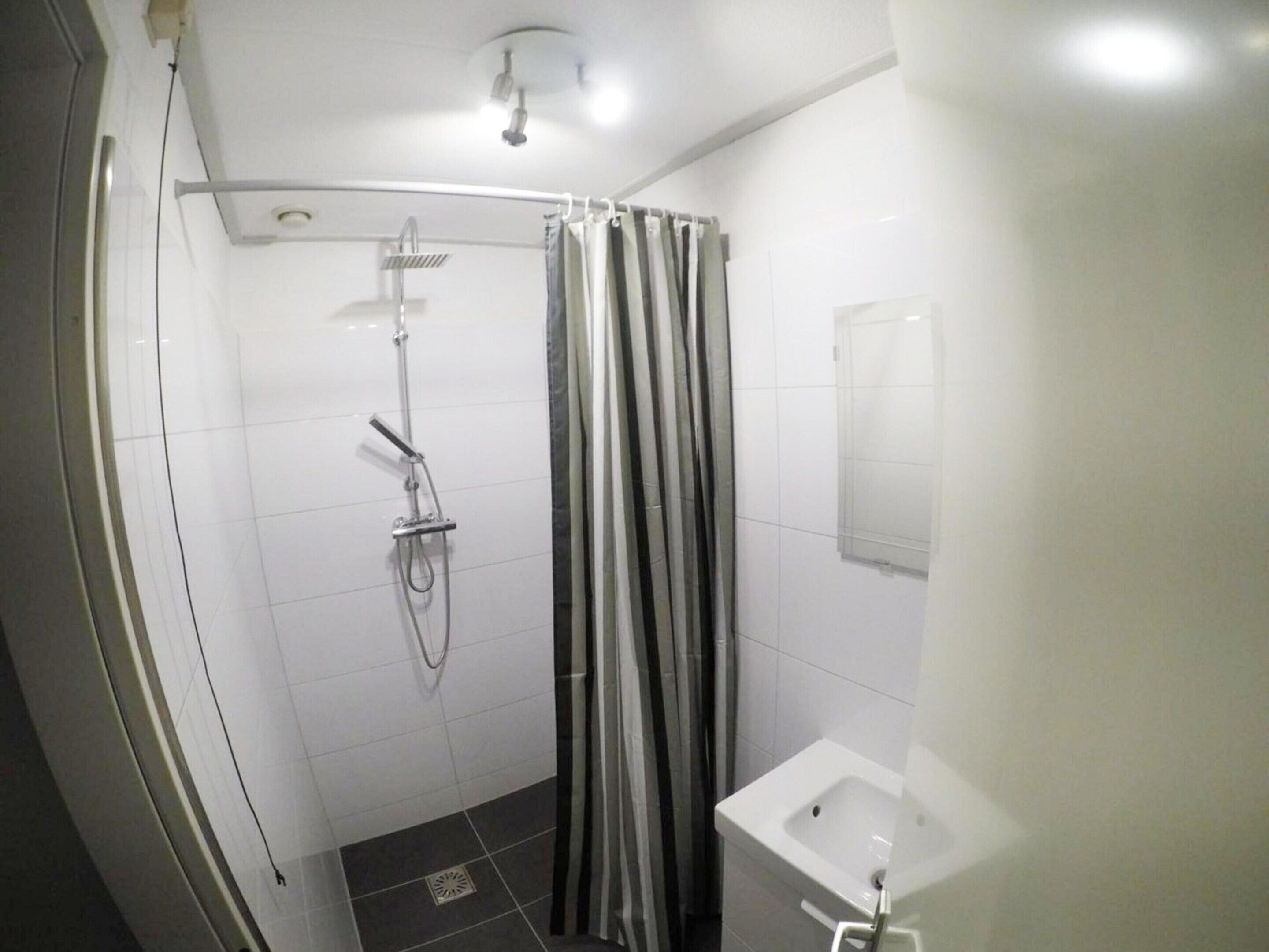 A bathroom with a shower, a toilet, and a sink.