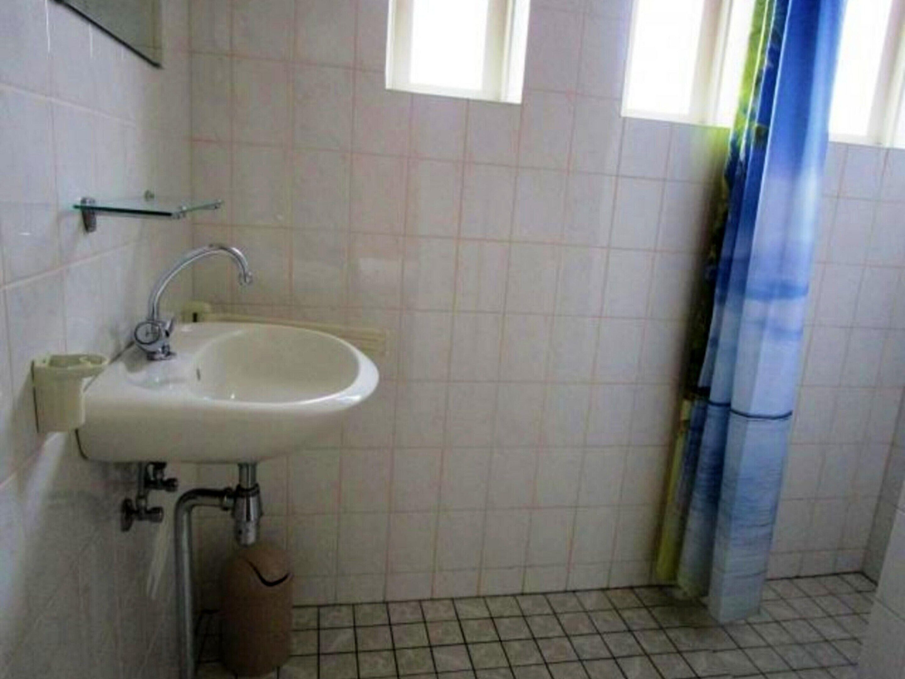 A bathroom with a sink, mirror, and window.