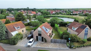 Zona residencial com casas, um lago e uma ponte.
