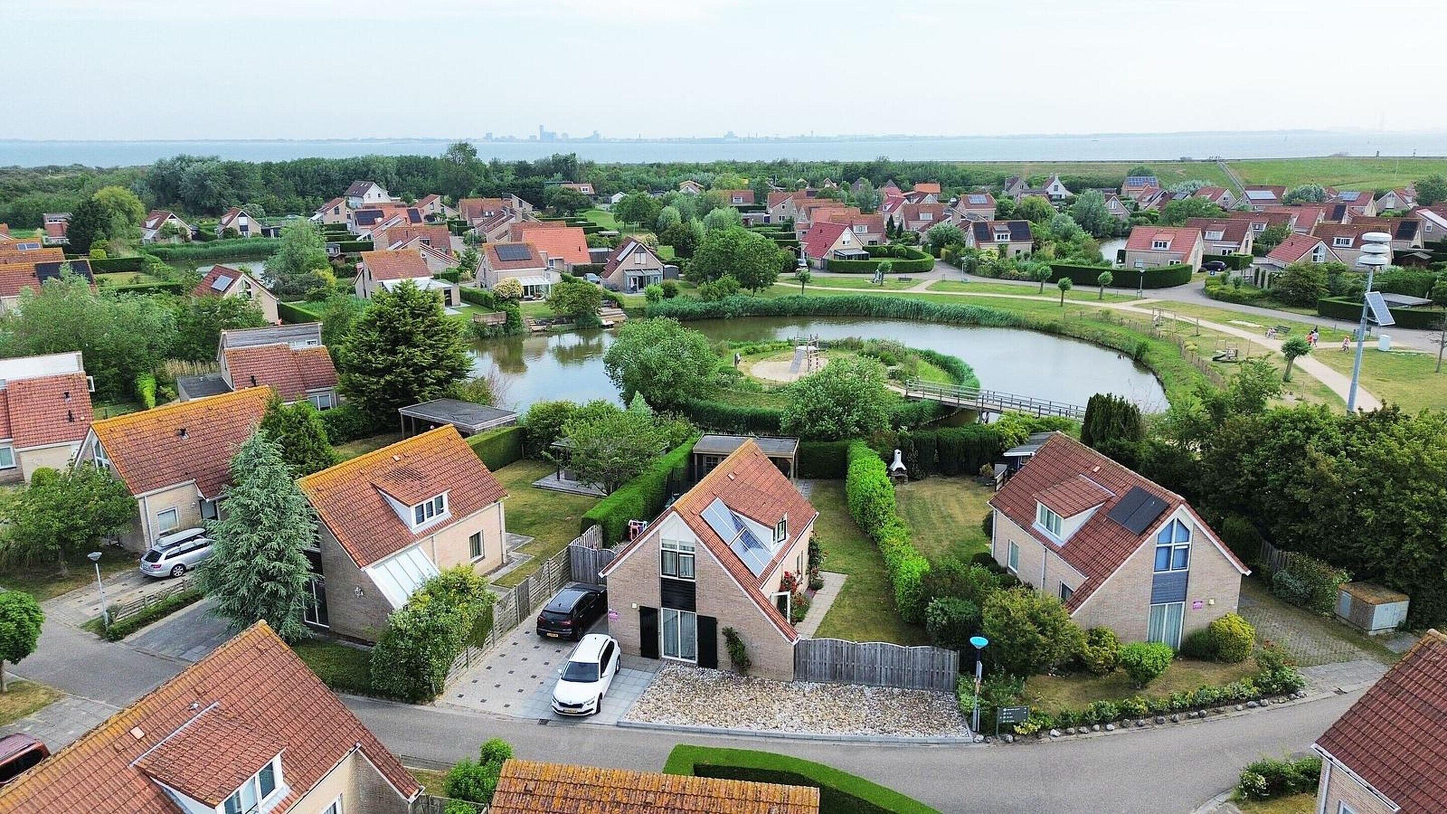 A residential area with houses, a curved water body, and a bridge.