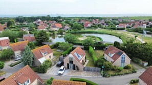 A residential area with houses, a curved water body, and a bridge. - Peaceful Coastal Bungalow (Breskens)