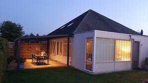 A single-story house with a covered patio, a dining area, and a large window. - Cozy House in Breskens Near Scenic Beaches (Breskens)