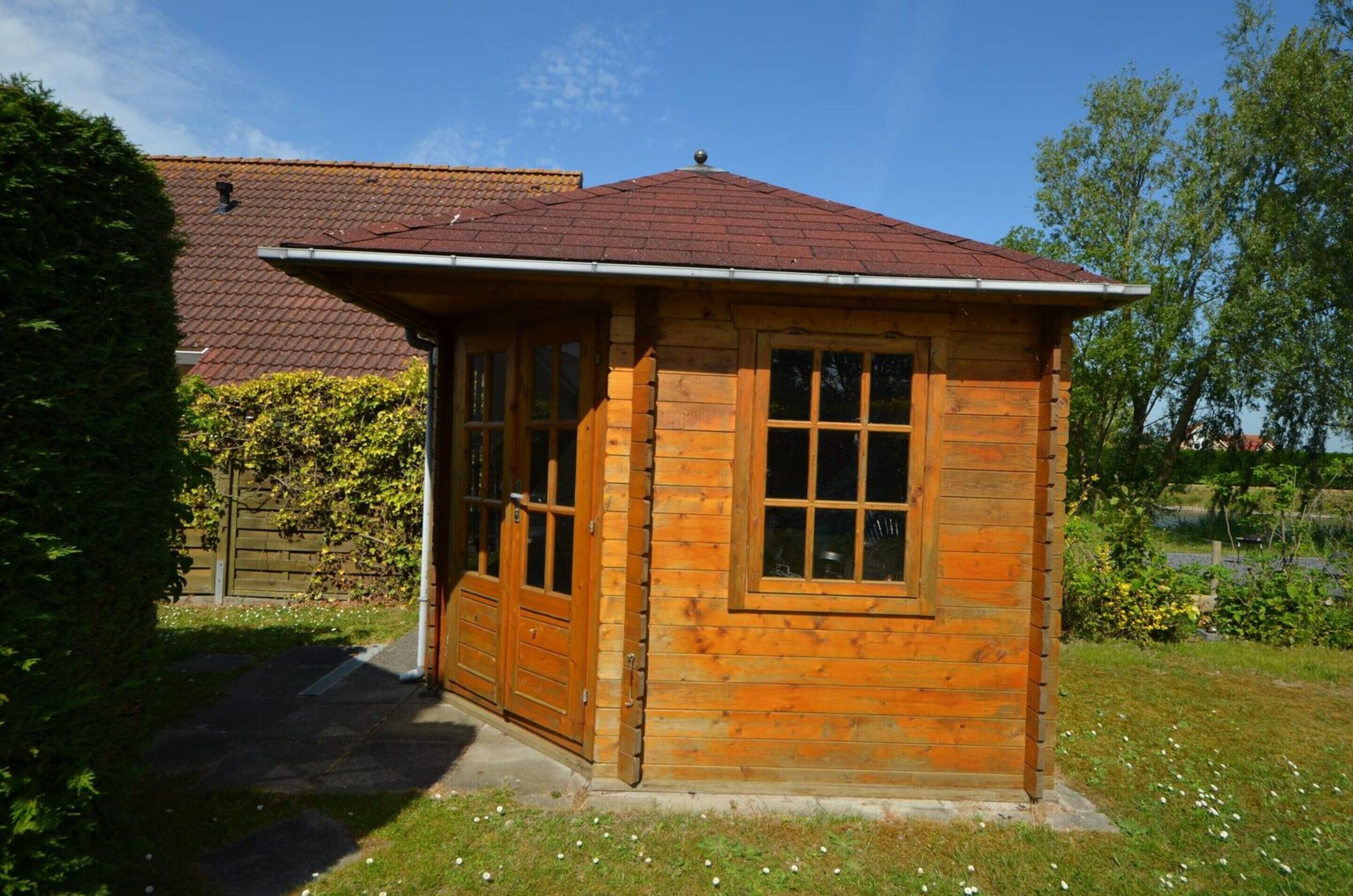 A small wooden cabin with a sloped roof, a front door, and a window.
