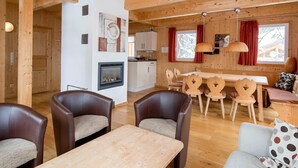 A wooden cabin interior with a dining area, kitchen, and seating. - Attractive Chalet With hot tub (Stadl-Predlitz)