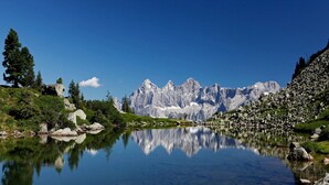 Un paysage de montagne avec un lac aux eaux limpides dans lequel se reflètent les sommets.