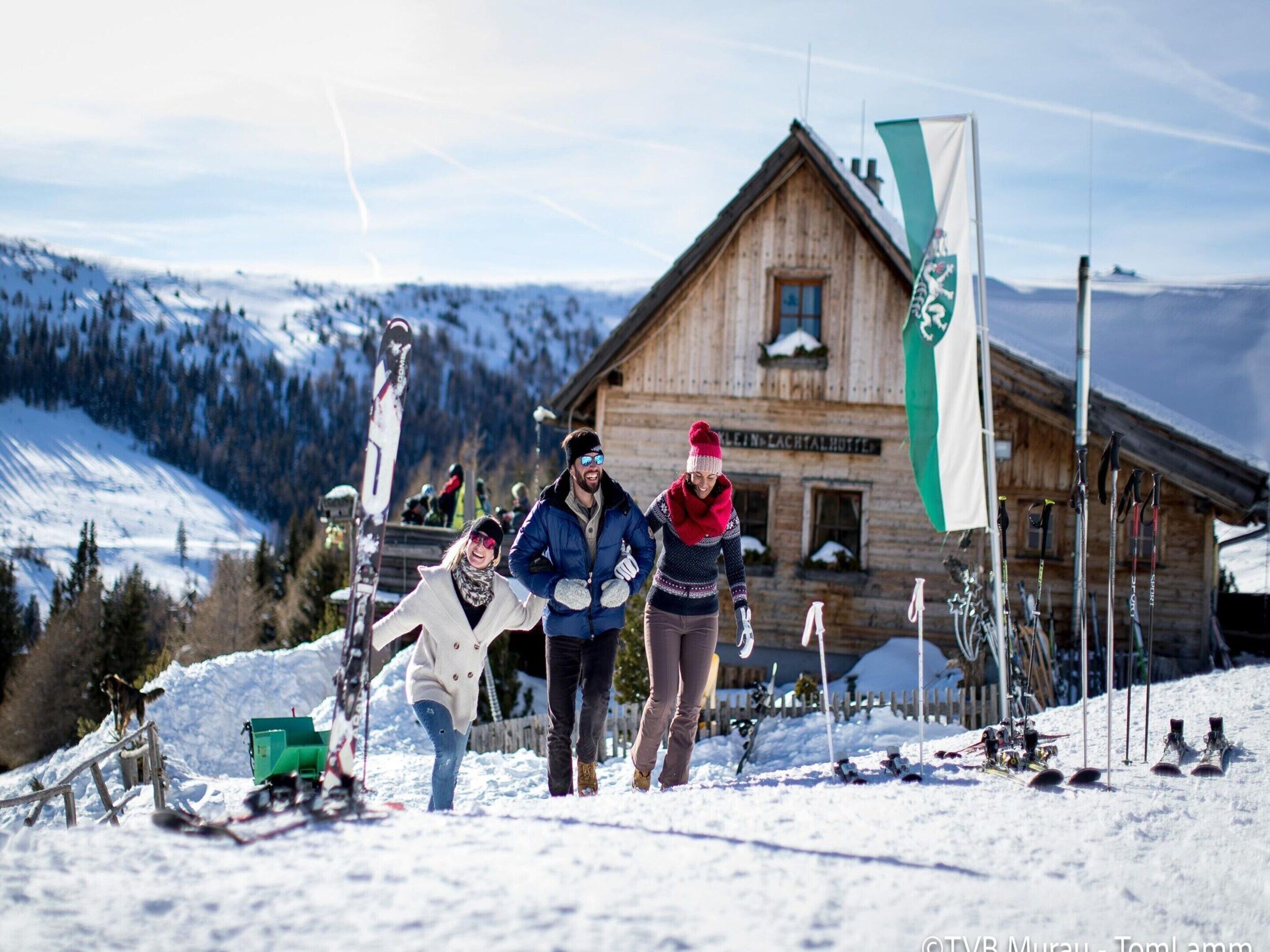 A wooden lodge with a ski slope in the background.