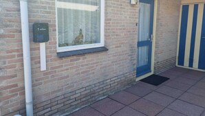 A brick building with a window, a door, and a mailbox. - Eco Retreat by the Sea (Breskens)
