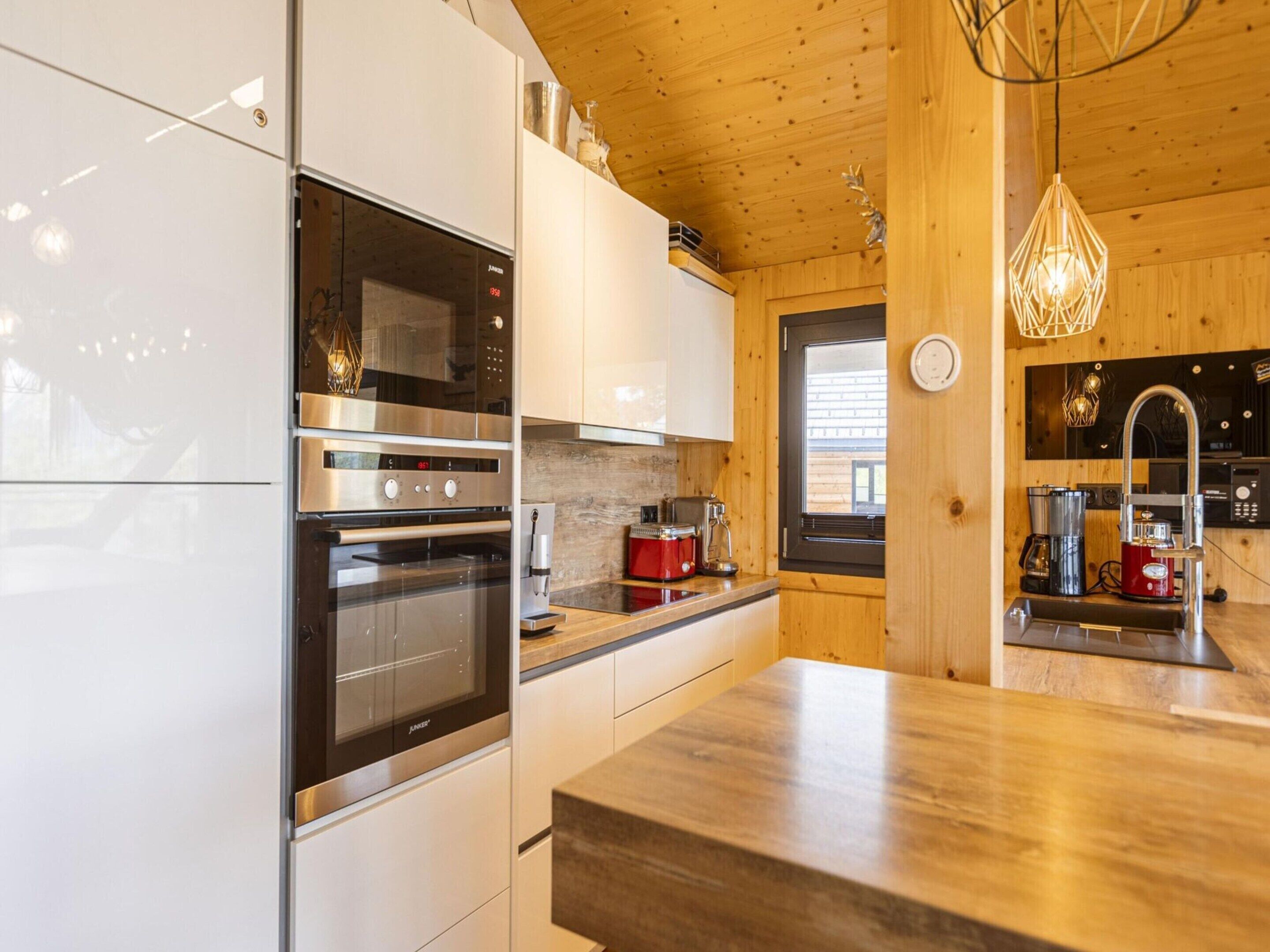 A modern kitchen with stainless steel appliances, wooden cabinetry, and a central island.