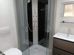A glass-enclosed shower with a handheld showerhead, a wall-mounted faucet, and a glass shelf above the sink. - House in Breskens Near Beach and Lighthouse (Breskens)