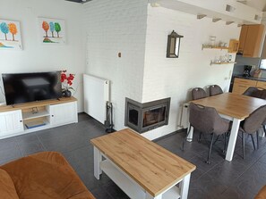 Un salon moderne doté d’une cheminée, d’un coin repas et d’une cuisine.