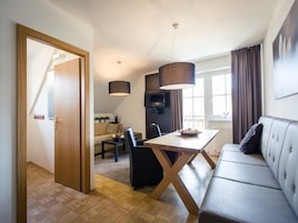 Una sala de estar moderna con un sofá, una mesa de comedor y un televisor.