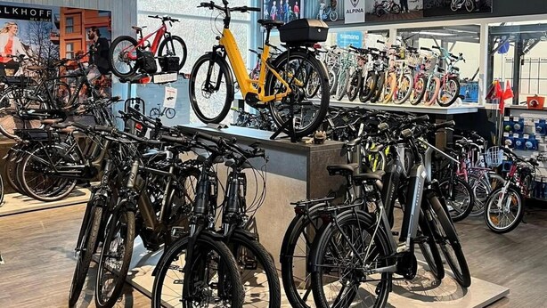Un magasin de vélos où sont exposés différents modèles, dont un vélo jaune bien visible.