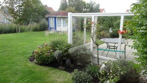 A garden with a white pergola, a table, and chairs. - Bungalow in Breskens Near the Lighthouse (Breskens)