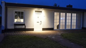 Ein modernes Gebäude mit einer großen Garagentür, einem kleinen Fenster mit einem Segelmodell und einer Satellitenschüssel.