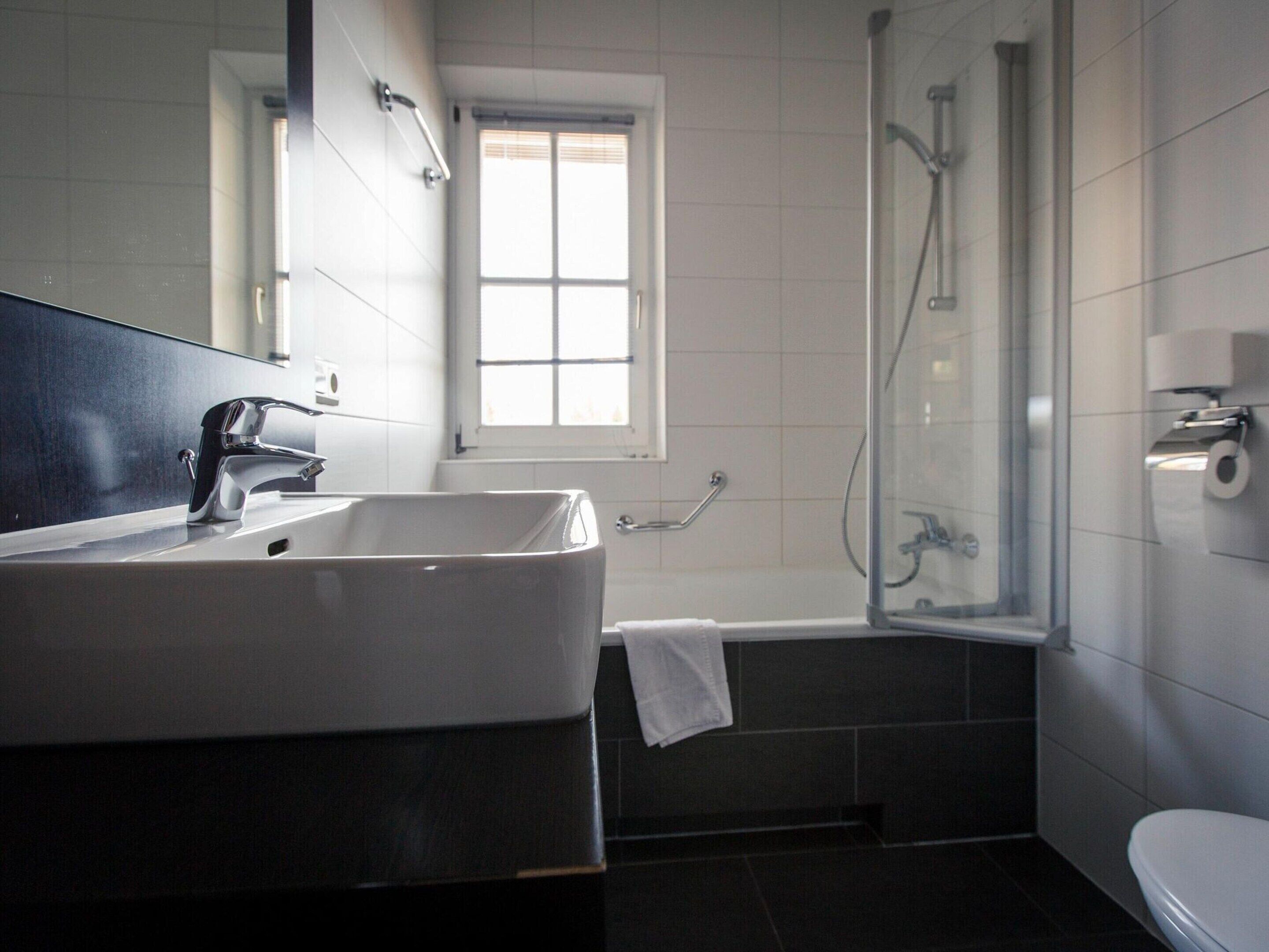 Un baño moderno con un lavamanos grande, una bañera y una ducha.