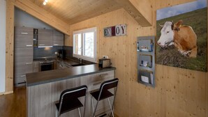 Et moderne køkken med trævægge, en bar og et billede af en ko.