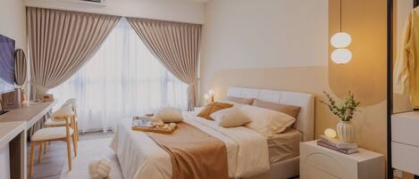A modern hotel room with a bed, bedside table, desk, and chair.