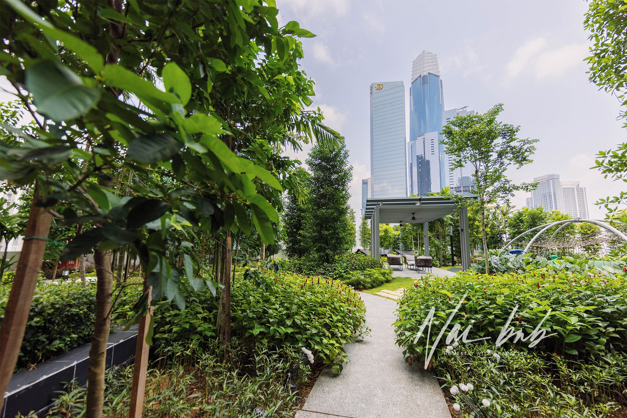 A pathway lined with lush greenery and a modern building in the background.