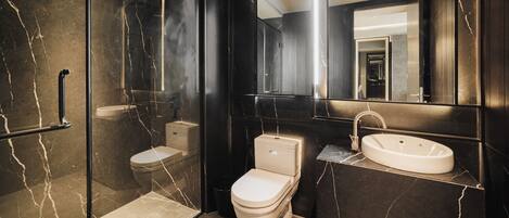 A modern bathroom with a glass-enclosed shower, a toilet, and a sink.