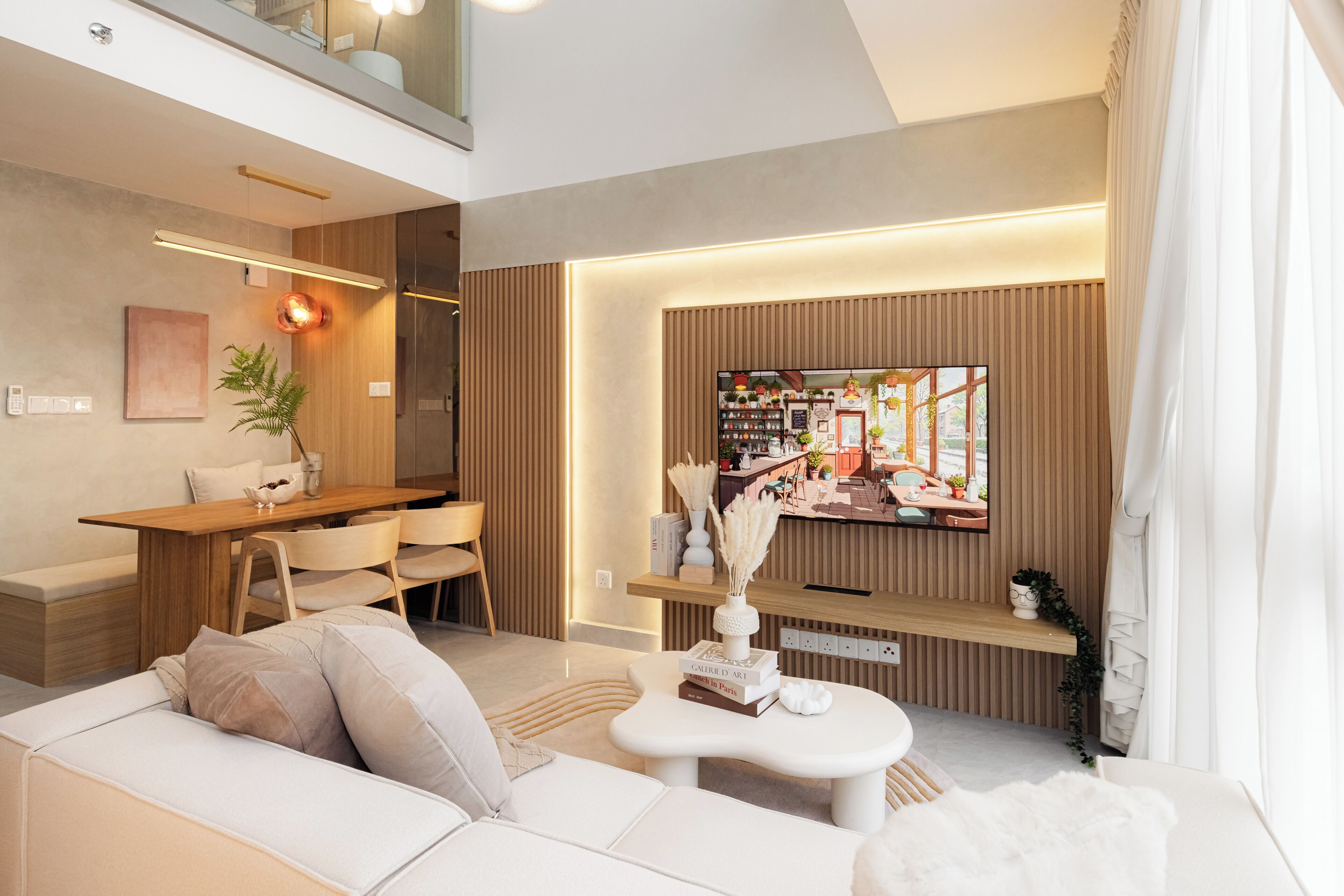 Ein modernes Wohnzimmer mit einer Couch, einem Couchtisch und einem an der Wand befestigten Fernseher.