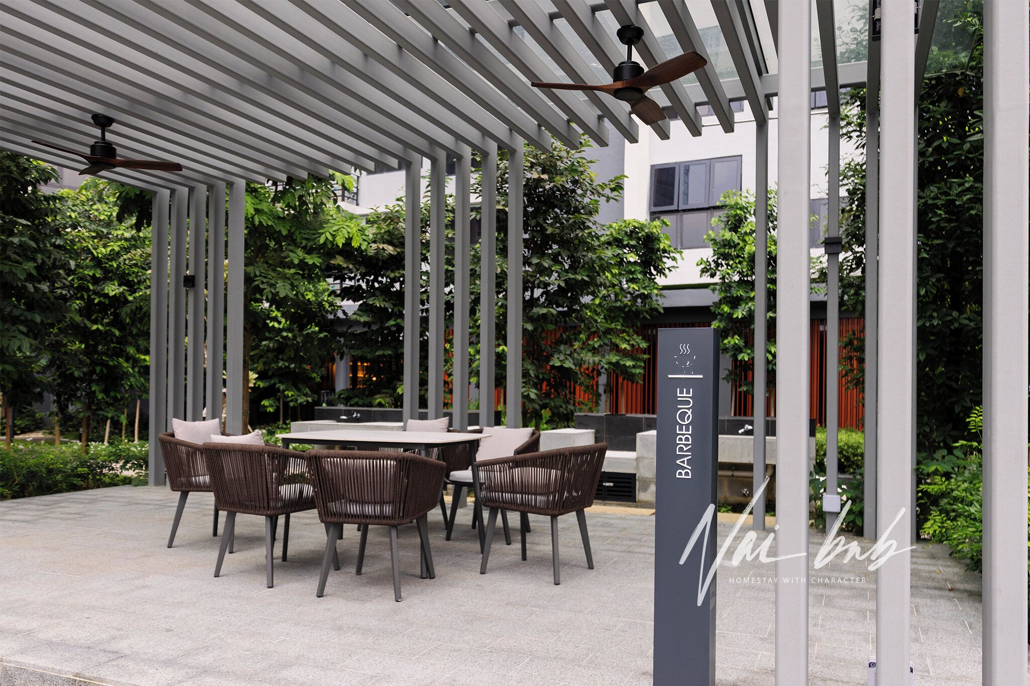 Un espacio al aire libre con patio, una pérgola, asientos y un letrero que dice 'BARBEQUE'.