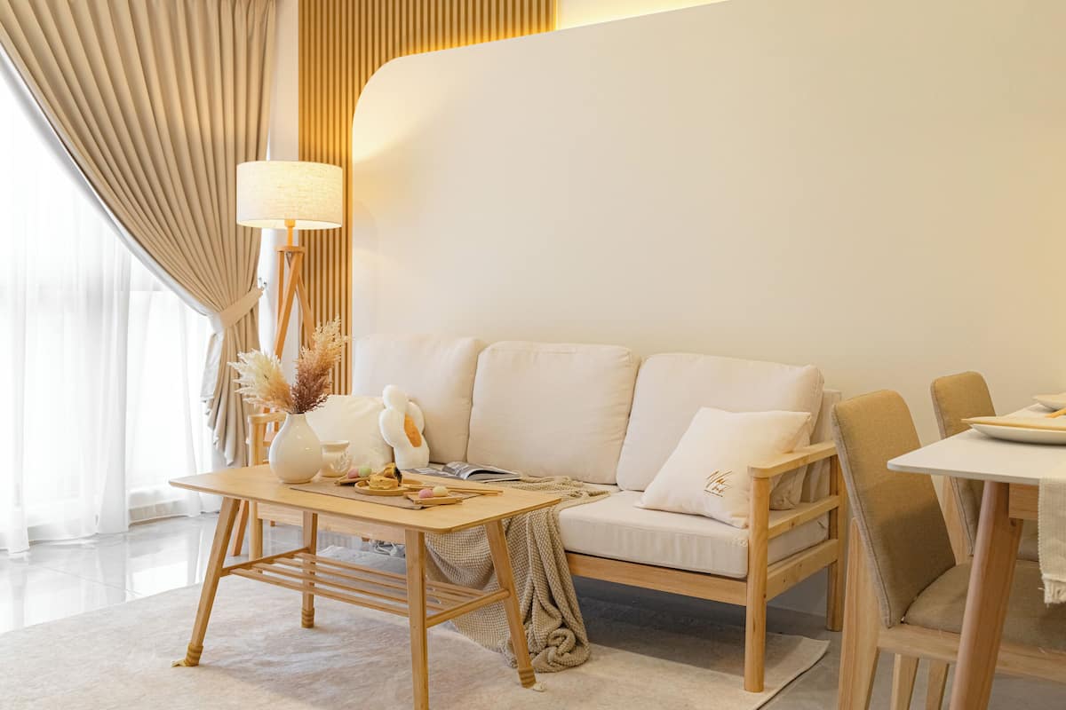 Una sala moderna con un sofá, una mesa y una lámpara.