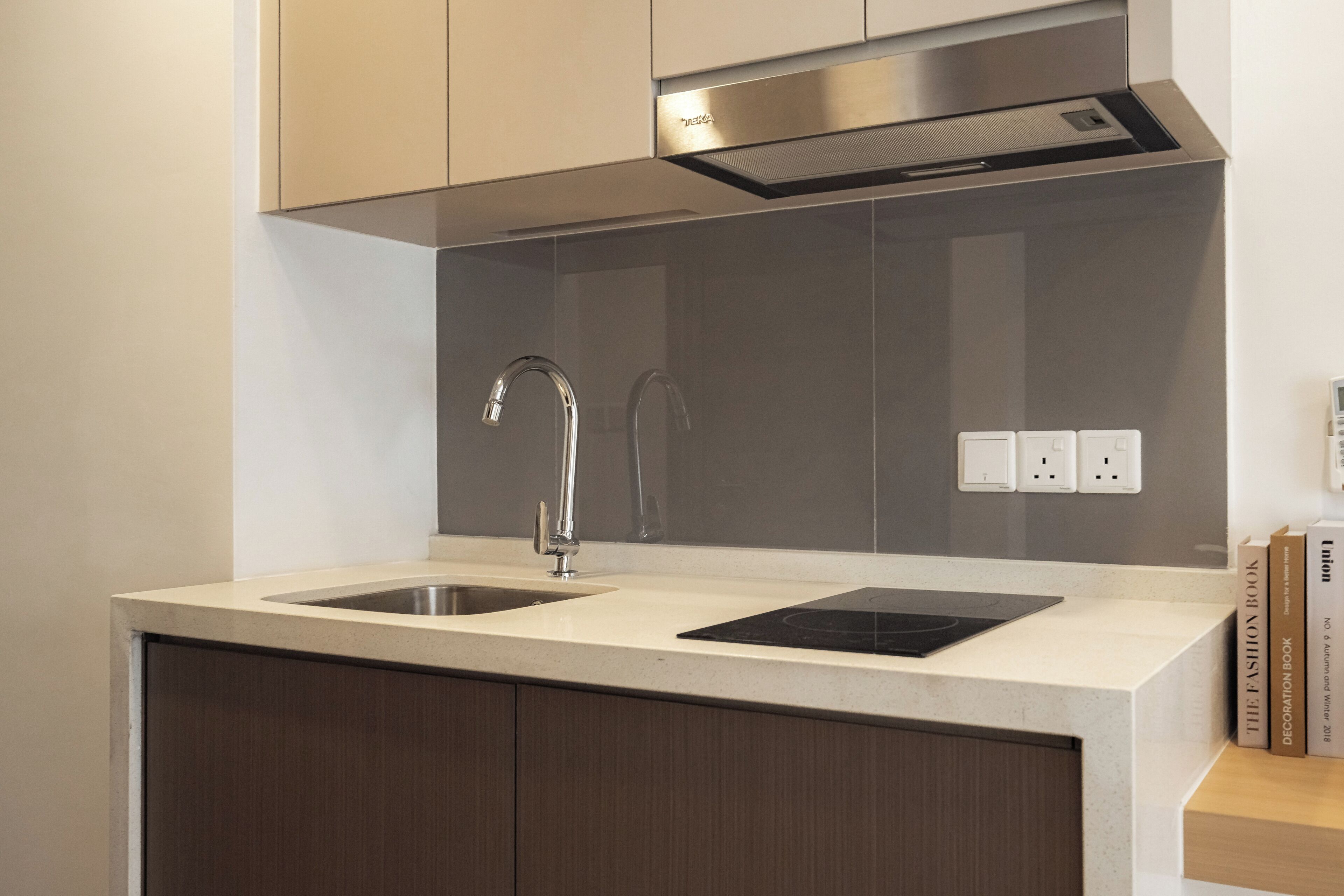 A modern kitchen with two sinks, a built-in stove, and a stainless steel range hood.
