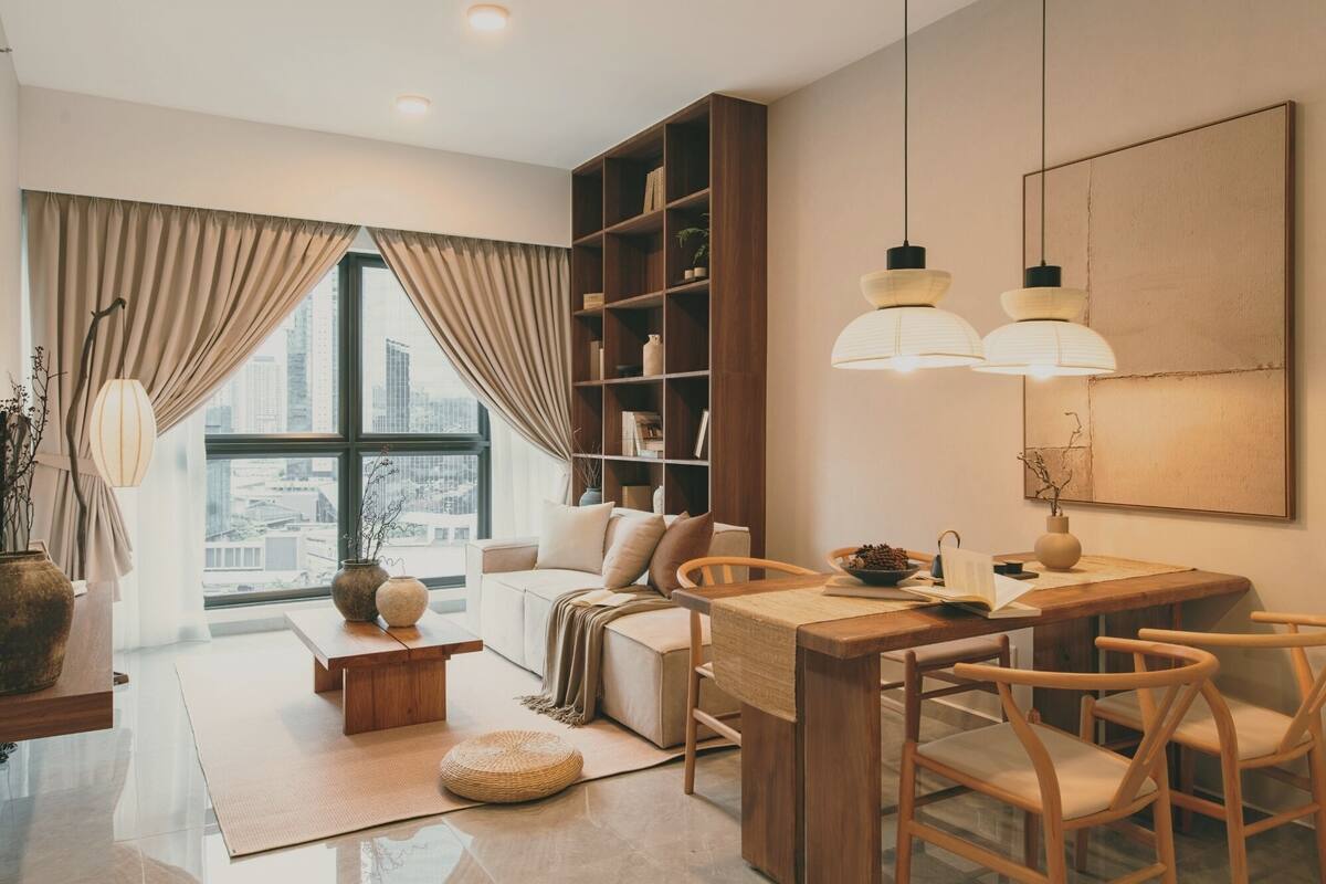 Una sala de estar moderna con un sofá, una mesa de centro de madera, una estantería y un comedor con sillas y una mesa.