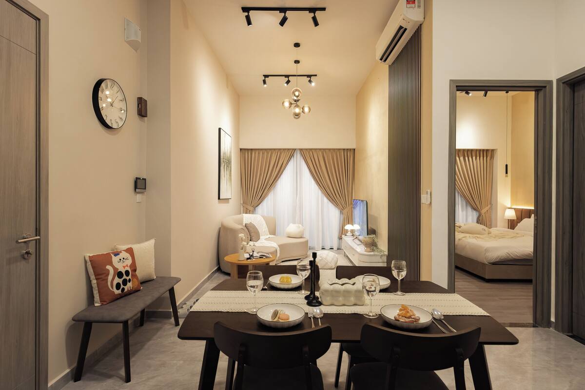 Habitación de hotel con zona de comedor, sofá, cama y baño.