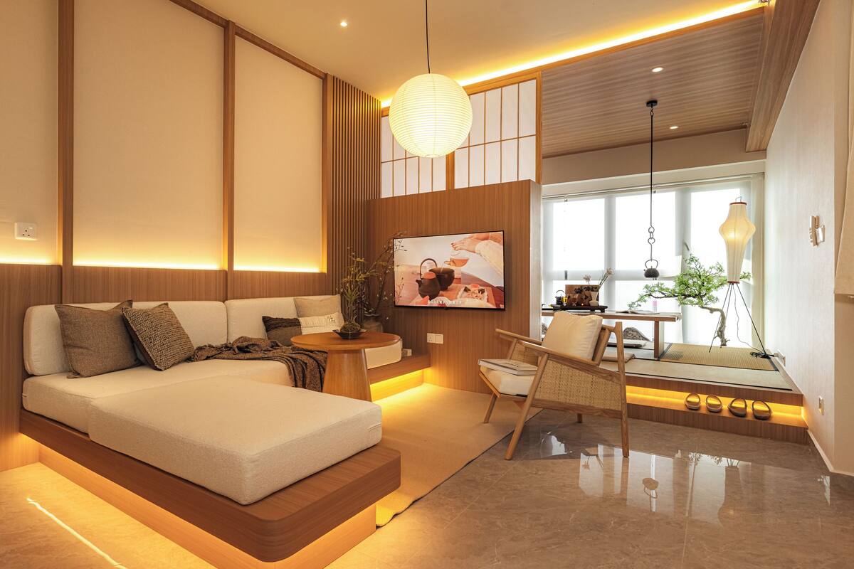 Una sala de estar moderna con un sofá, un comedor y un televisor montado en la pared.