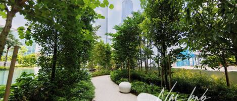 Un camí flanquejat per vegetació i grans testos esfèriques, que condueix cap a un edifici modern.