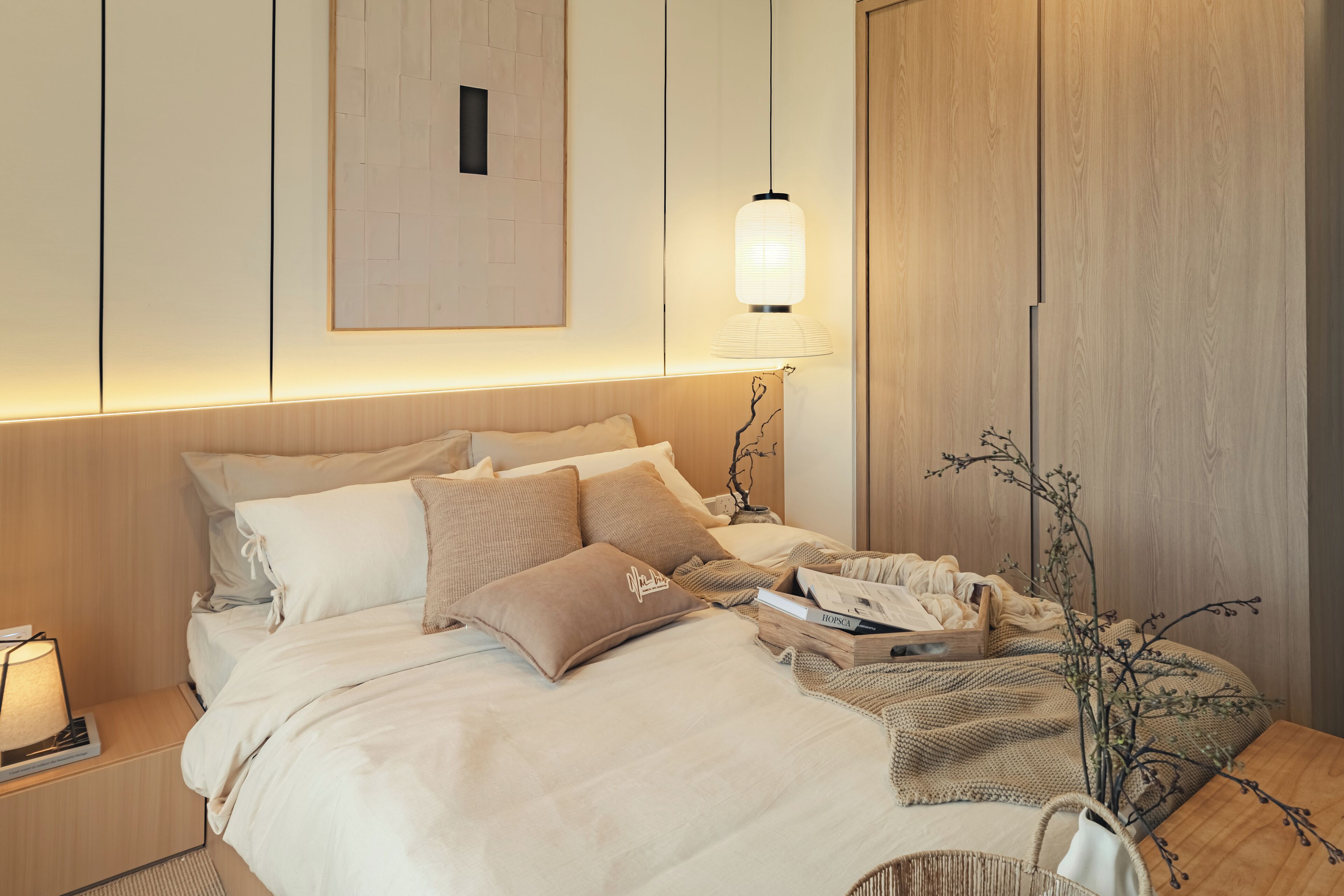 Ein ordentlich eingerichtetes Hotelzimmer mit Bett, Nachttisch, Lampe und einer dekorativen Vase.
