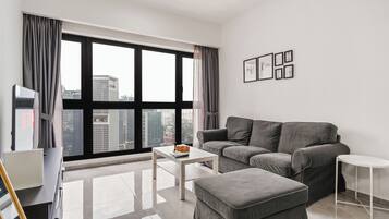 A modern living room with a grey sofa, a white coffee table, and a small white side table.