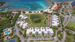 Vista aérea de un resort con un patio central, edificios circundantes y un puerto deportivo.