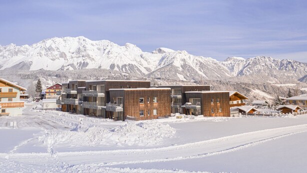 A modern building complex with multiple units, surrounded by snow-covered mountains. - Apartment Near Ski Slope (Schladming)