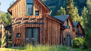A wooden cabin with a steep gable roof, a large window, and a small door. - Welcoming Chalet With Terrace (Sankt Georgen am Kreischberg)