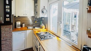 Een kleine keuken met een vaatwasser, fornuis en spoelbak.