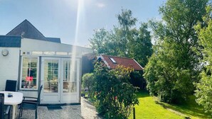 Een huis met een patio, een eettafel en stoelen.