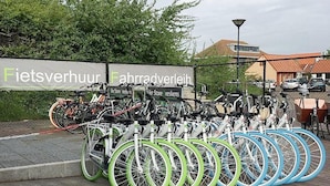 Ein Fahrradstellplatz mit mehreren Fahrrädern und einem Schild im Hintergrund.