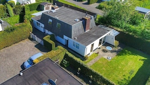 A modern two-story house with a sloped roof, a small attached garage, and a solar water heater. - Family Stay - Near Beach (Breskens)
