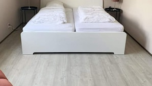 A double bed with white bedding, two bedside tables with lamps, and a light-colored wooden floor. - Spacious Stay Near the Sea (Breskens)