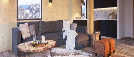 A cozy living room with a wooden ceiling, a gray sofa with decorative pillows, a round wooden coffee table, and a leather ottoman.