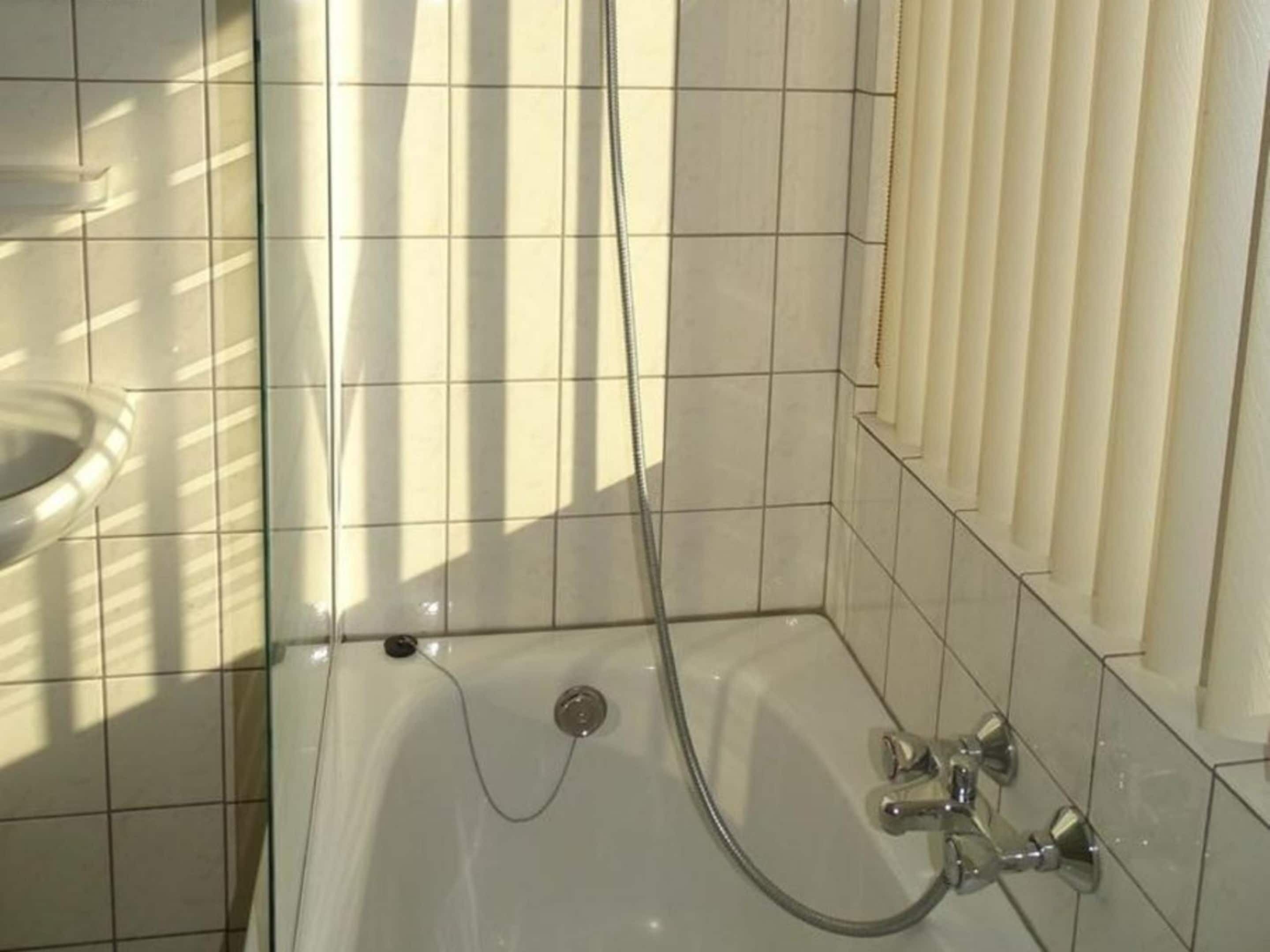 Un baño con bañera, ducha e inodoro.