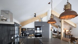 Una cocina moderna con una isla central, electrodomésticos de acero inoxidable y vigas de madera.