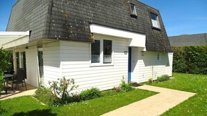 A single-story house with a dark roof, white siding, and a small front yard with a pathway. - Holiday Home Breskens Near Scenic Beaches (Breskens)