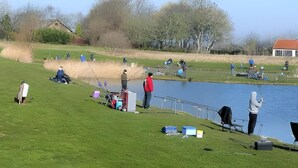 A grassy area with a pond, fishing equipment, and a few people fishing. - Holiday Home Breskens Near Scenic Beaches (Breskens)