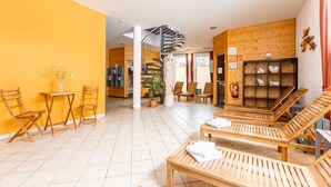 A hotel lobby with wooden furniture, a staircase, and a reception area. - Cosy Apartment With Fireplace (Sankt Georgen am Kreischberg)