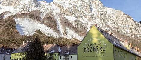 A building labeled "Alpin Resort ERZBERG" with a mountainous backdrop.